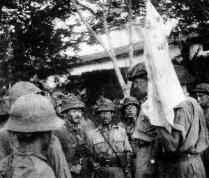 The British surrender Singapore on 15 February 1942. Lieutenant-General Arthur Percival (1887-1966), the British commander, is the tall figure just behind the white flag surrounded by Japanese soldiers 