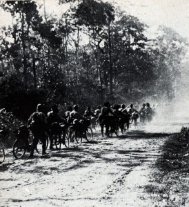 Japanese soldiers on bicycles move down a jungle road in 1942
