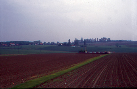 Wijtschate church spire rises above the Messines Ridge beyond Spanbroekmolen CWGC cemetery.