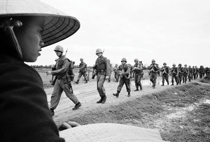 Black and white photograph of soldiers on the road in Vietnam.